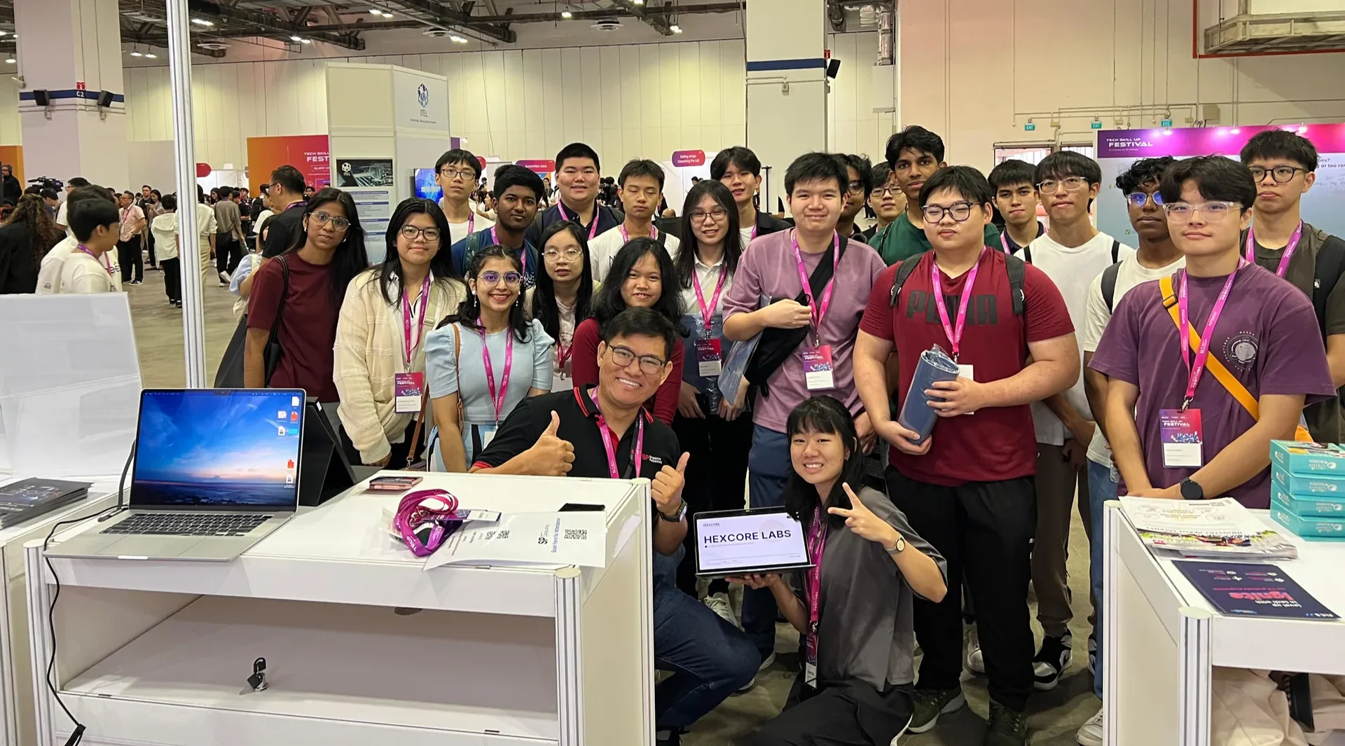 Group of students and professionals wearing lanyards gathered at a booth during the IMDA Tech Skill Up Festival 2025