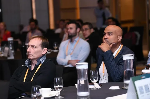 Cybersecurity leaders and CISOs seated at a table during a live hacking demo presentation at an indoor event
