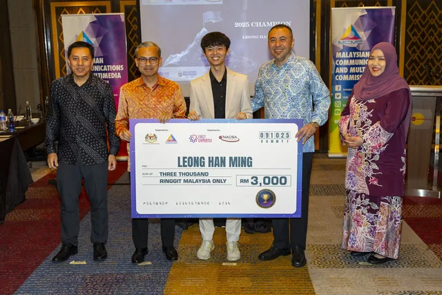 Five people holding a large cheque for three thousand ringgit at an indoor event with Malaysian government logos visible in the background